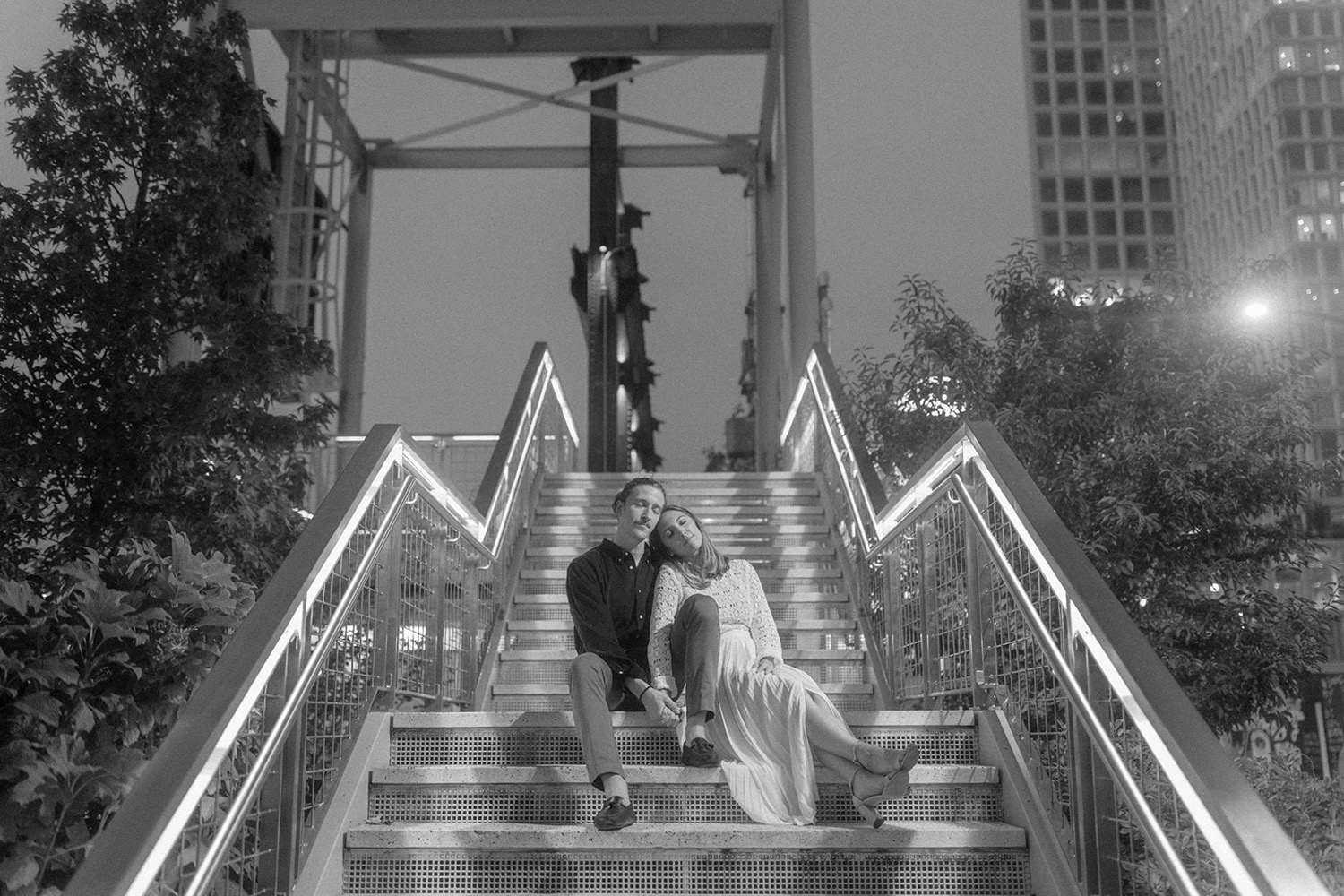 couple sitting on stairs in the dark brooklyn engagement session